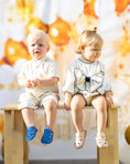 Load image into Gallery viewer, mace and co kids clothing dubai, linen romper with long sleeves and a bow on the front, for girls ages infant, toddler and up to seven years old. Pictured with the boys linen shirt and shorts set. Both outfits perfect for formal occasions, birthday parties and playtime.